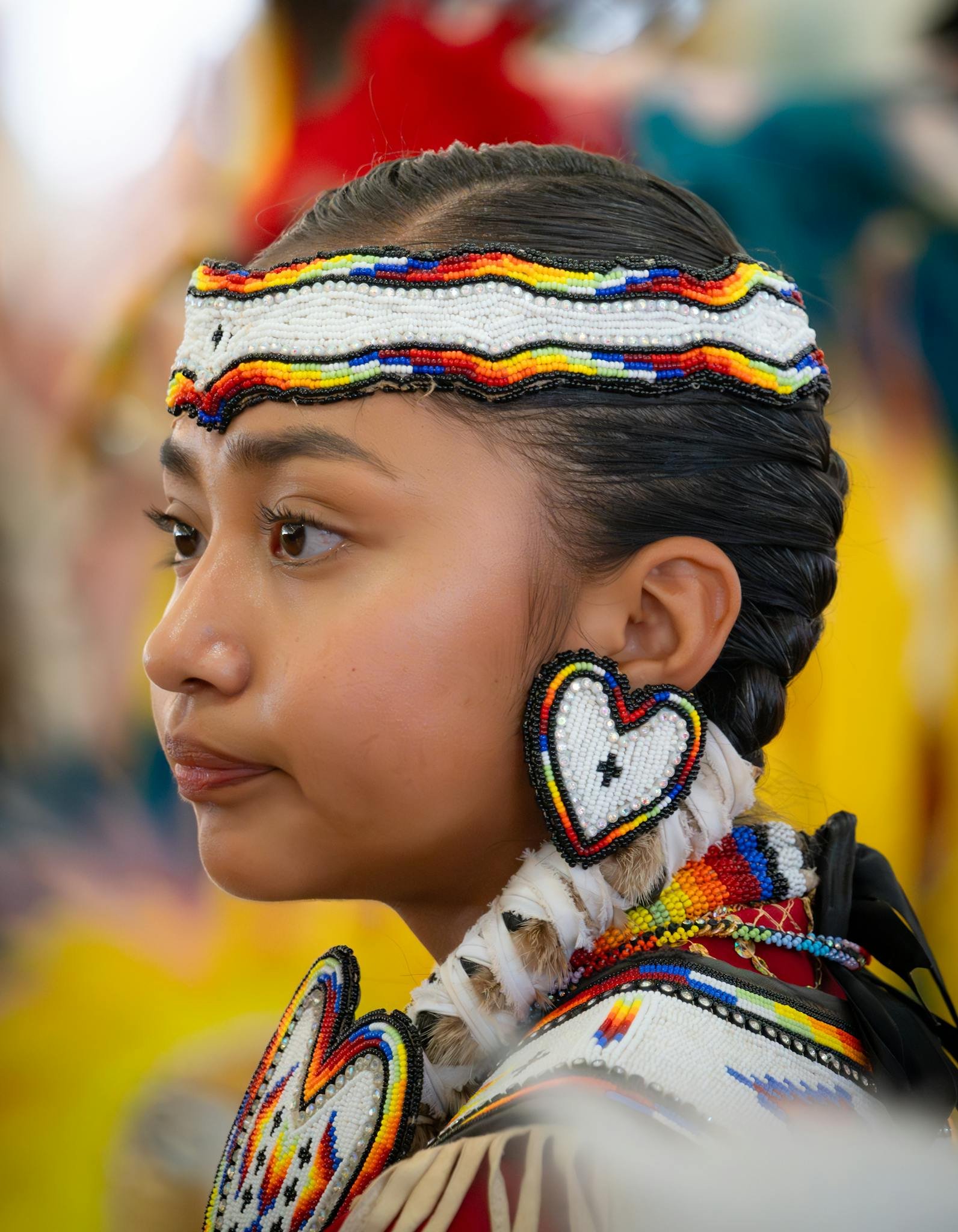 Portrait of a young Native American girl wearing traditional regalia with beadwork.