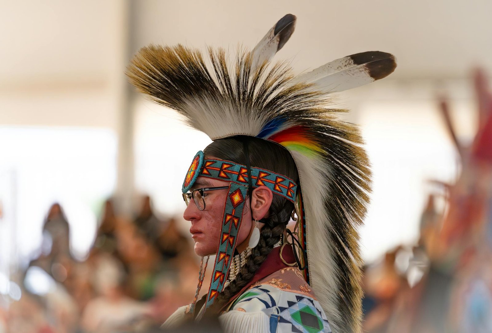 Vivid portrait of a Native American man in traditional attire at a Morongo Valley powwow.